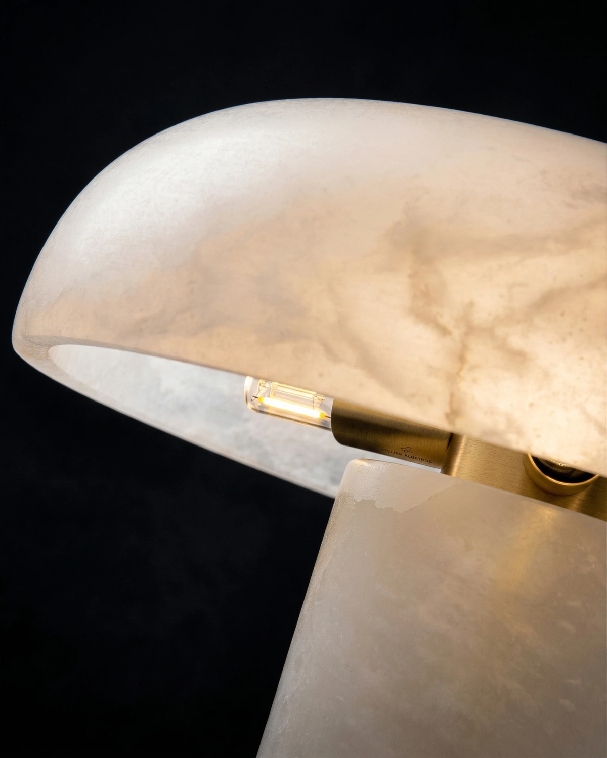 Close-up of the lit alabaster dome and brass core of the alabaster table lamp OBSI No.01