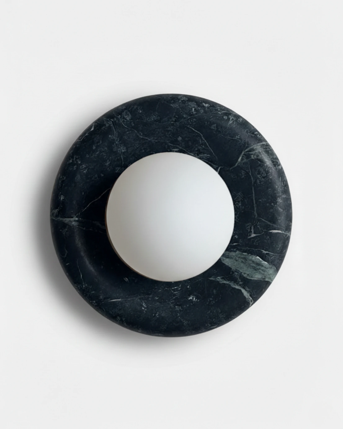 Alabaster wall sconce LATTE No.02 in Dark Green, deep green stone ring holding a white frosted sphere, unlit