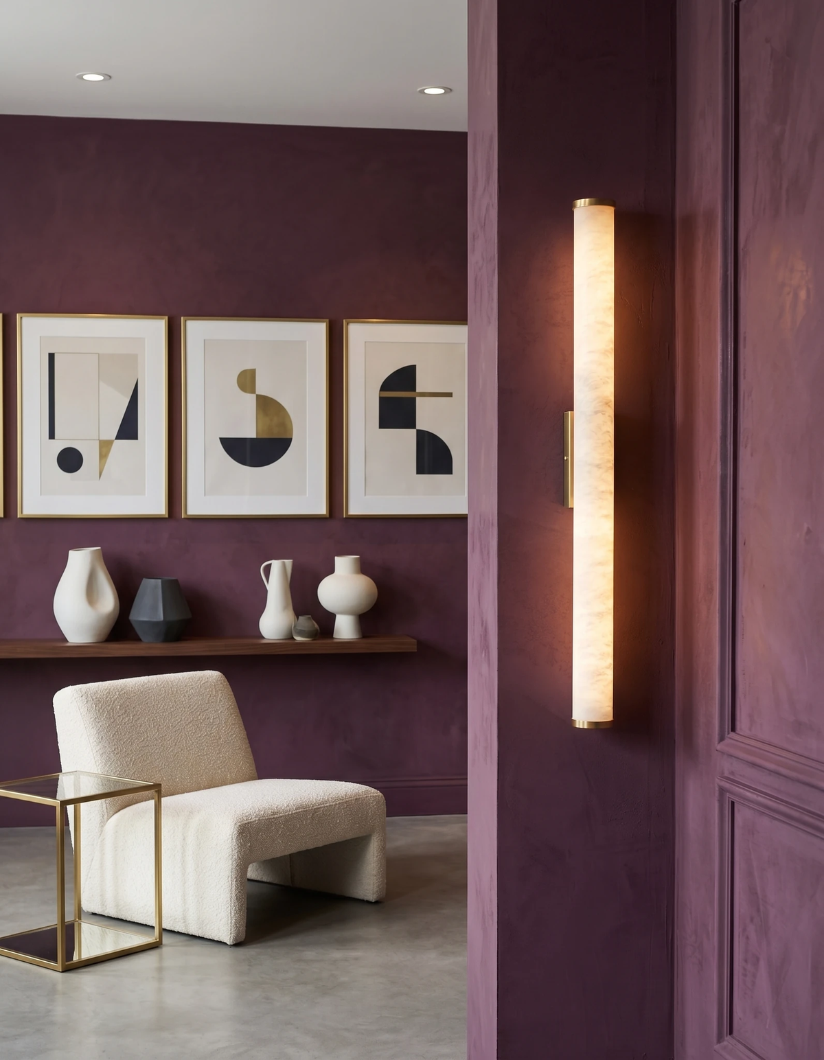 Alabaster wall sconce NEBBIA No.01 on a Warm Gold bracket, lit on a plum paneled wall by a doorway with framed prints