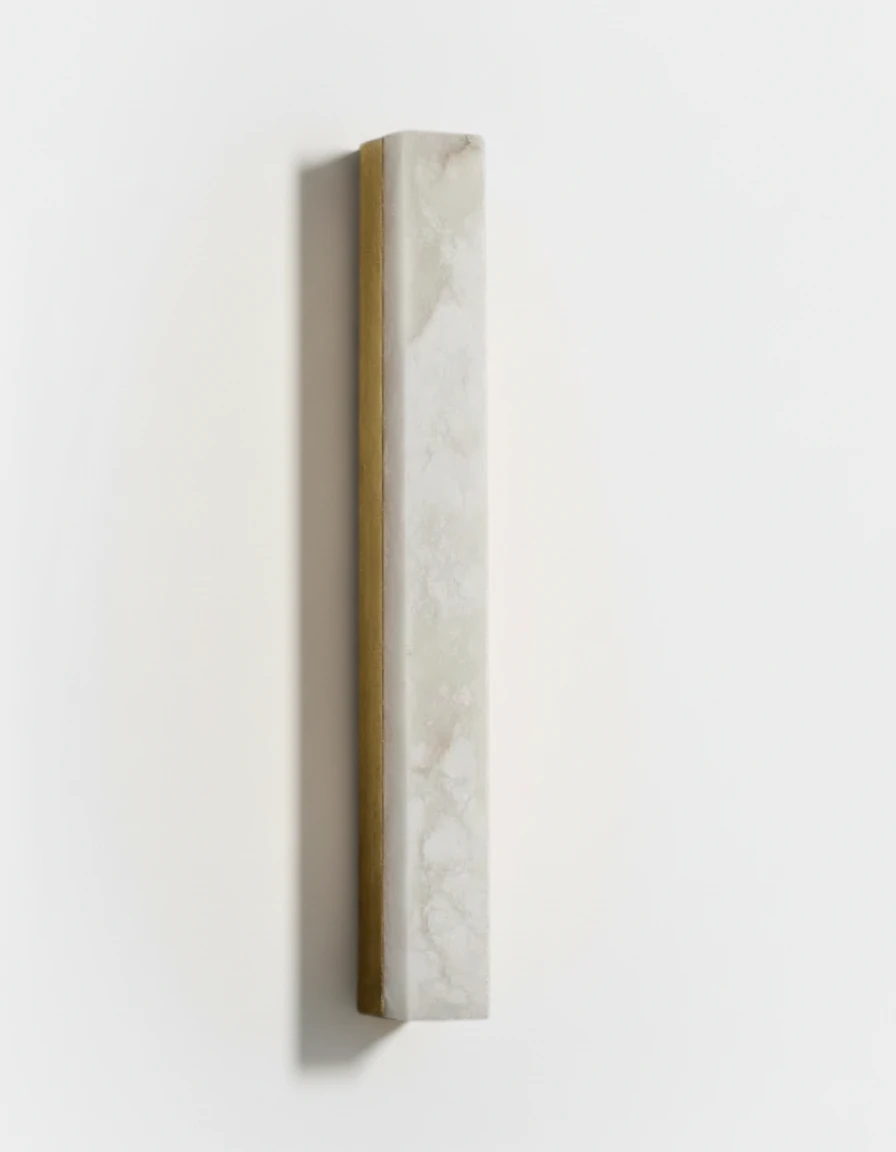 Alabaster wall sconce NEBBIA No.02 on a brass bar, tall column switched on against a white wall