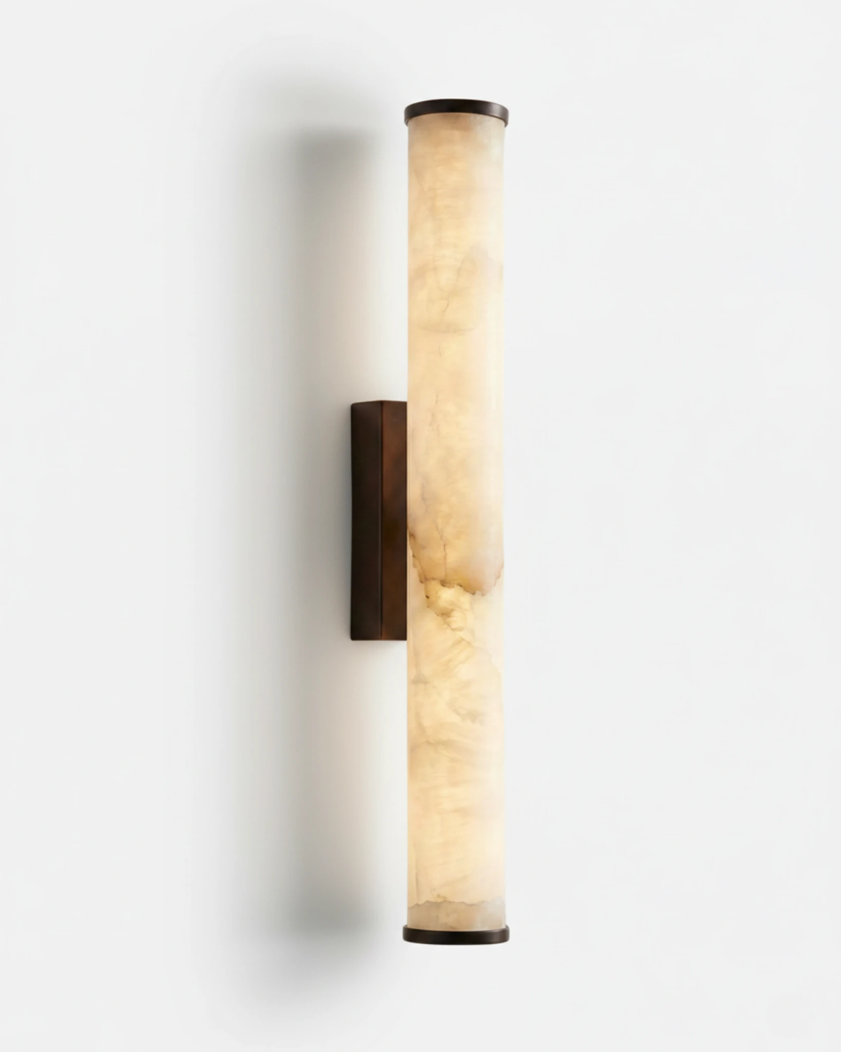 Alabaster wall sconce NEBBIA No.01, 24 in tube on a Dark Bronze bracket, switched on against a white wall