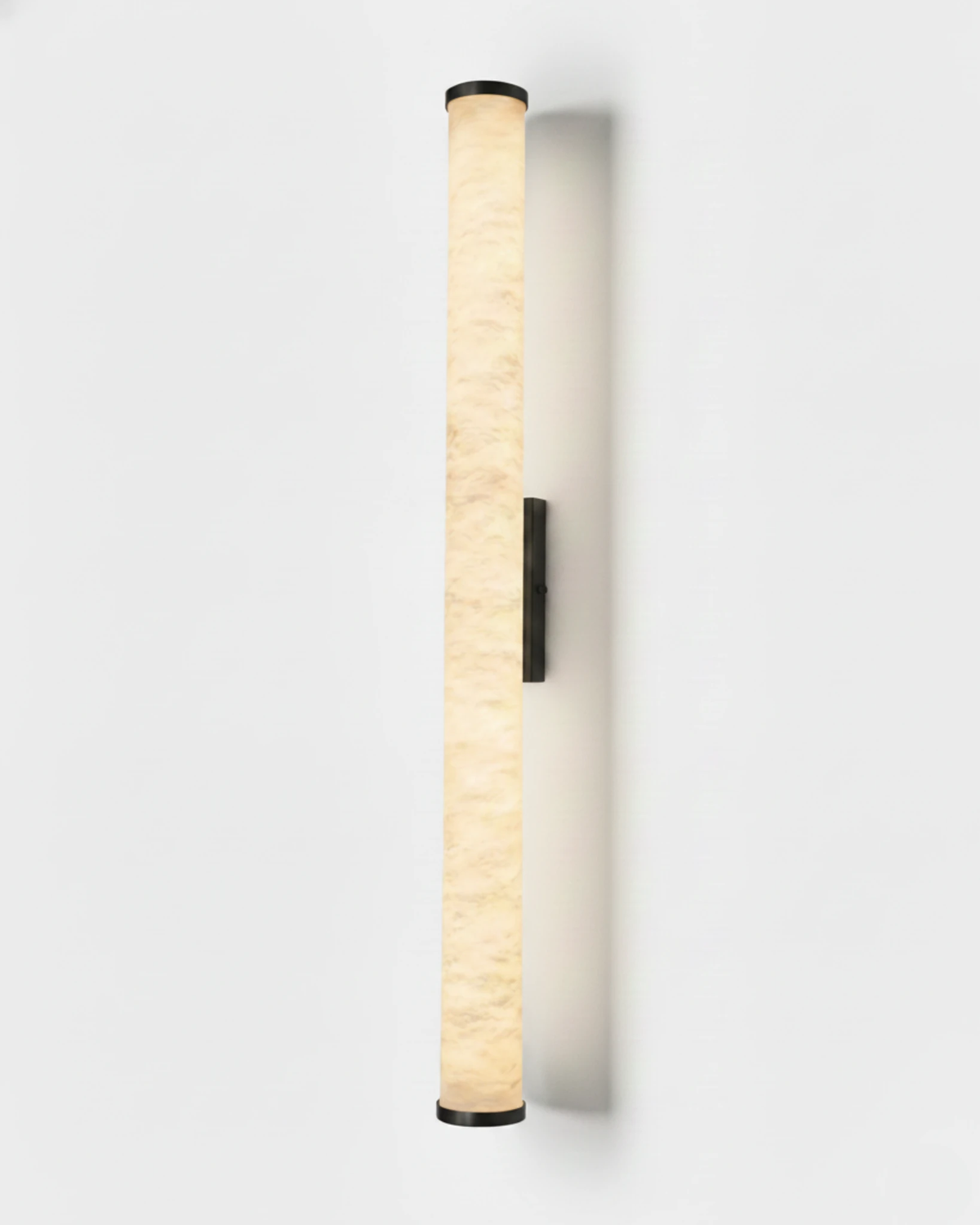 Alabaster wall sconce NEBBIA No.01, 31 in tube on a Dark Bronze bracket, switched on against a plain wall