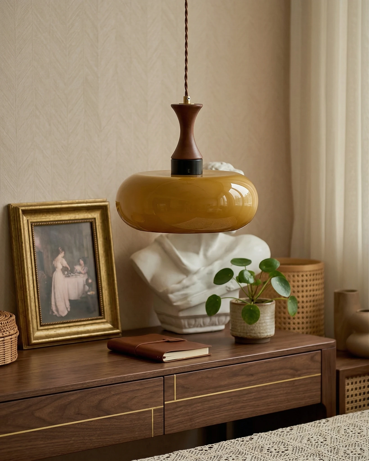 Amber glass pendant light OVIA No.04, disc shade hanging above a walnut sideboard with a framed print