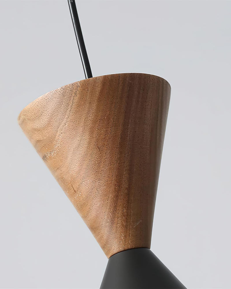 Close-up of the walnut cone top and black cord of the TARO No.01 brass pendant light
