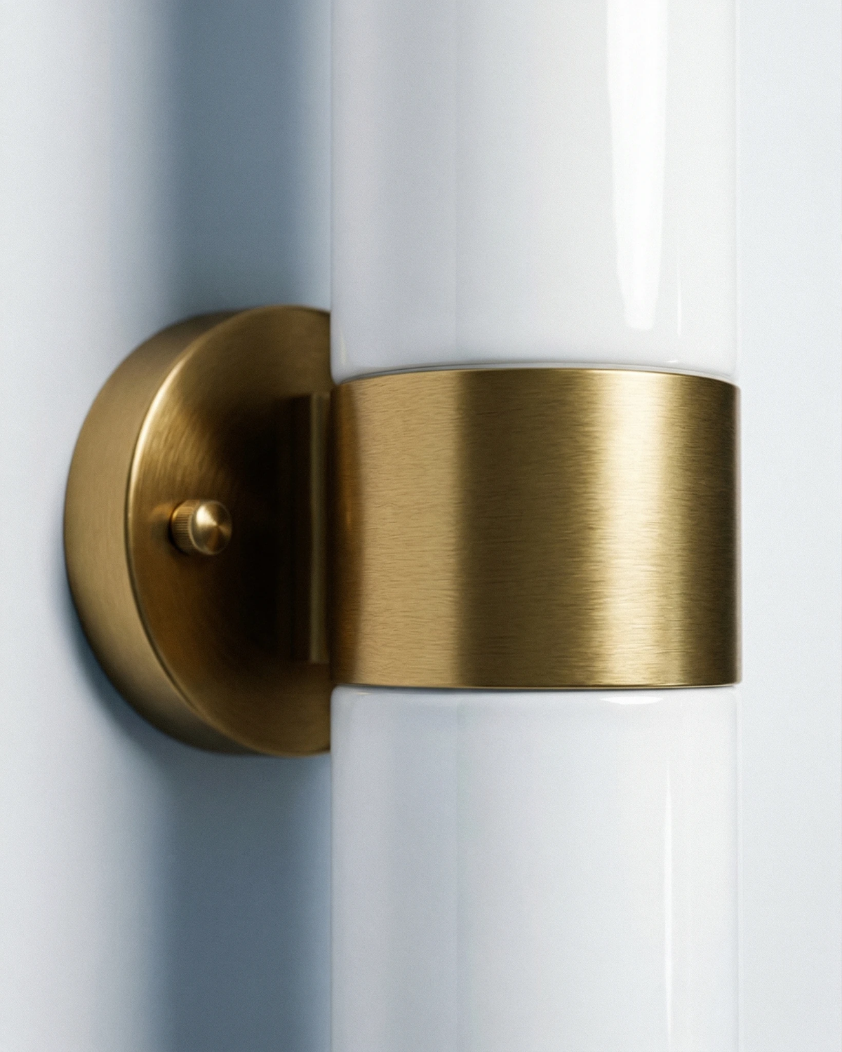 Close-up of the brushed brass center band and wall bracket of the COMETA No.01 brass wall sconce