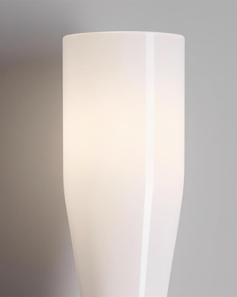 Close-up of the white hourglass glass diffuser of the DALIA No.02 brass wall sconce, switched on