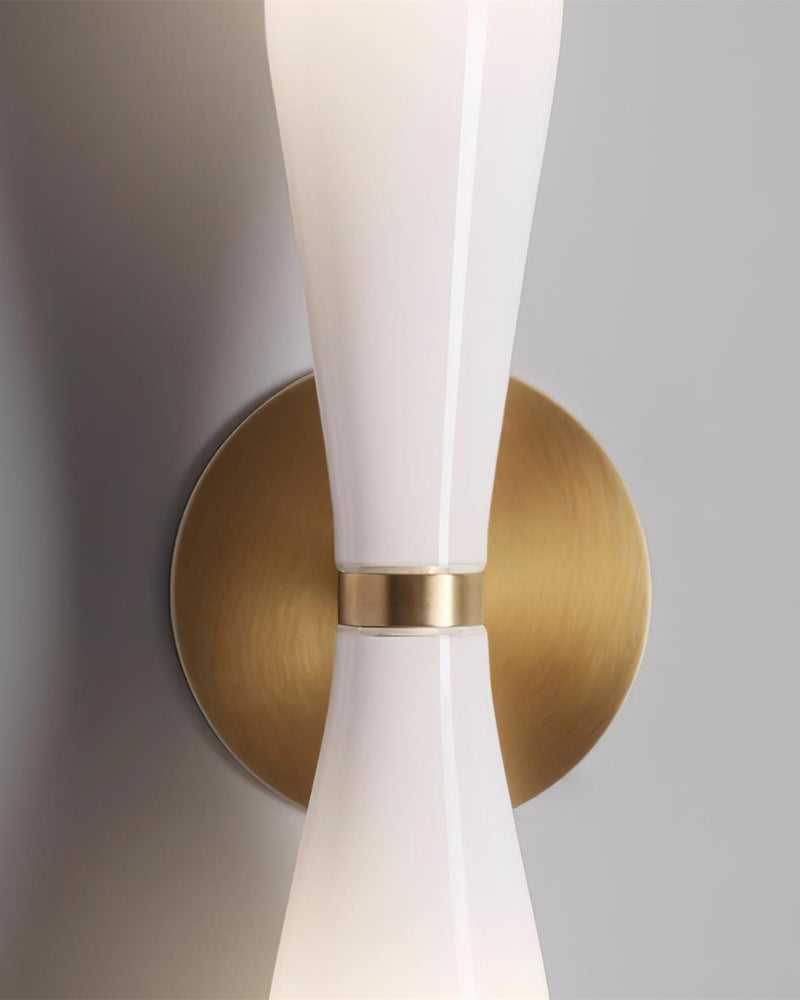 Close-up of the round brass backplate and pinched glass waist of the DALIA No.02 brass wall sconce