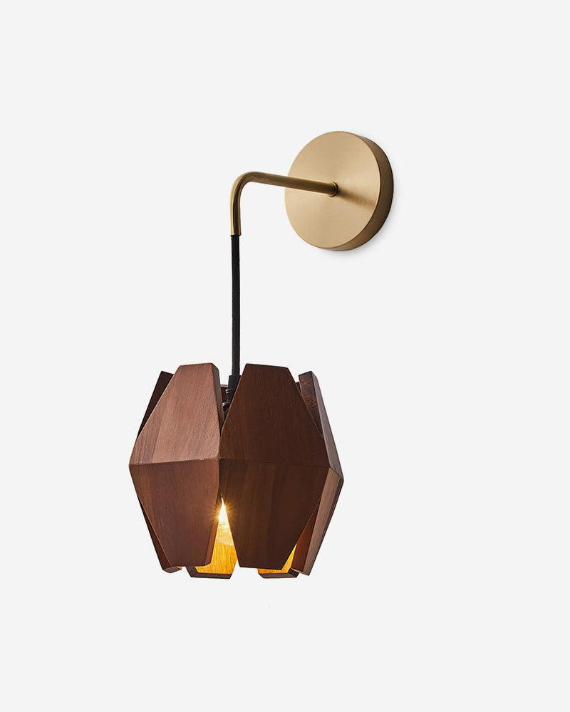 Brass wall sconce NODO No.01 in Dark Walnut, faceted wood shade hung from a brass arm and round plate, switched on