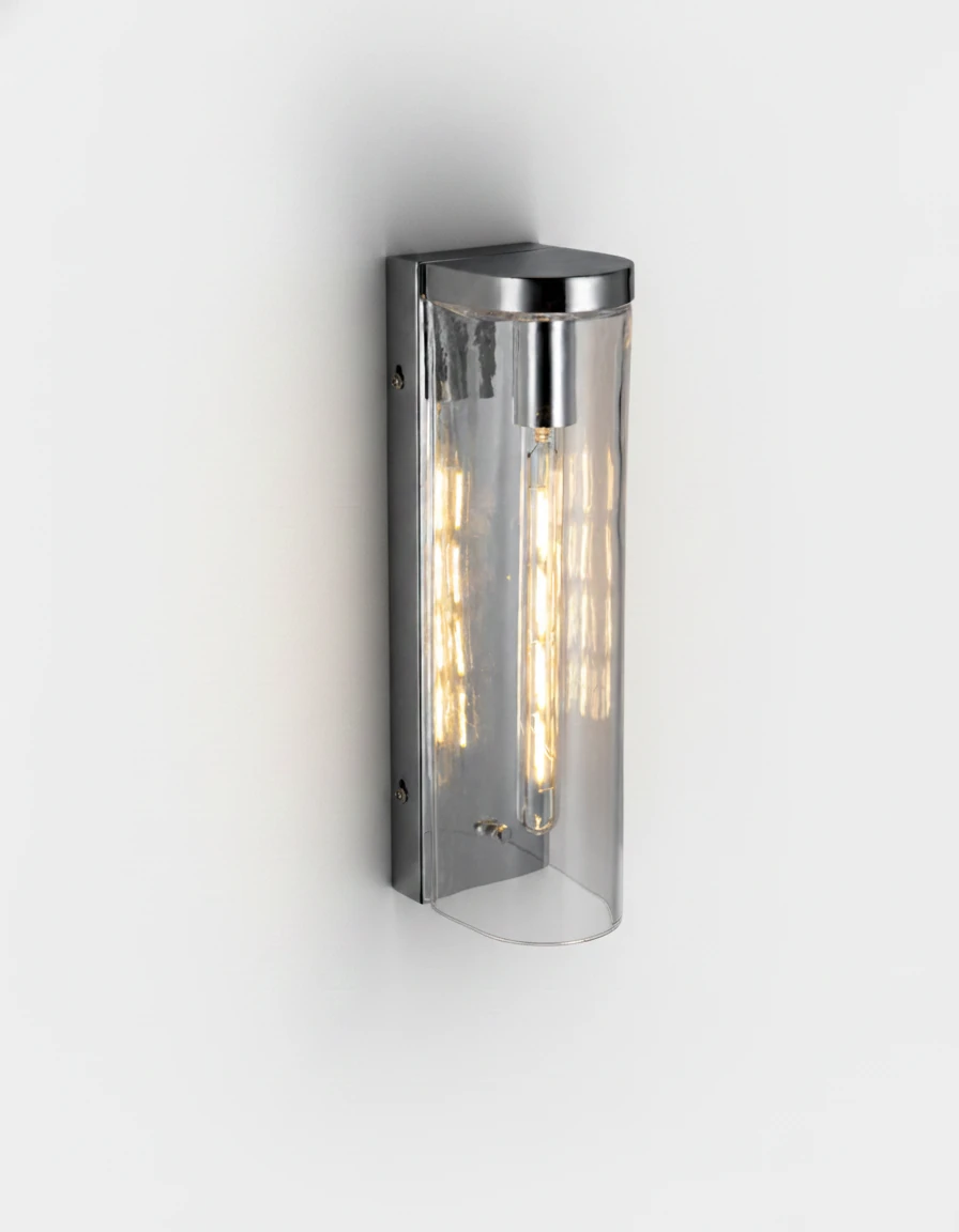Brass wall sconce PILA No.01 Single Column in clear glass with polished chrome frame, filament bulb glowing