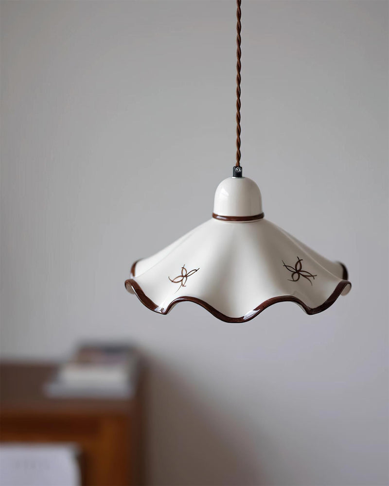 Ceramic pendant light CAPRI No.01 seen from below the rim, wavy shade with two painted flowers in a softly blurred room