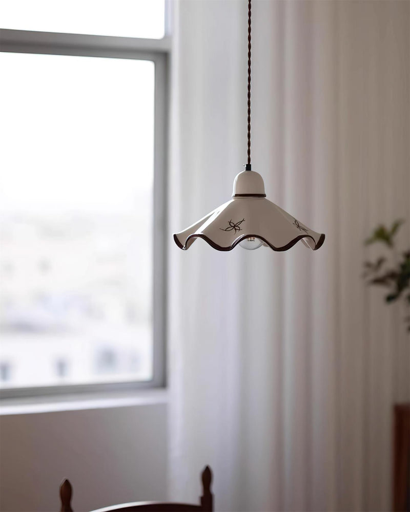Ceramic pendant light CAPRI No.01 on a long twisted cord beside a bright window above the back of a wooden chair