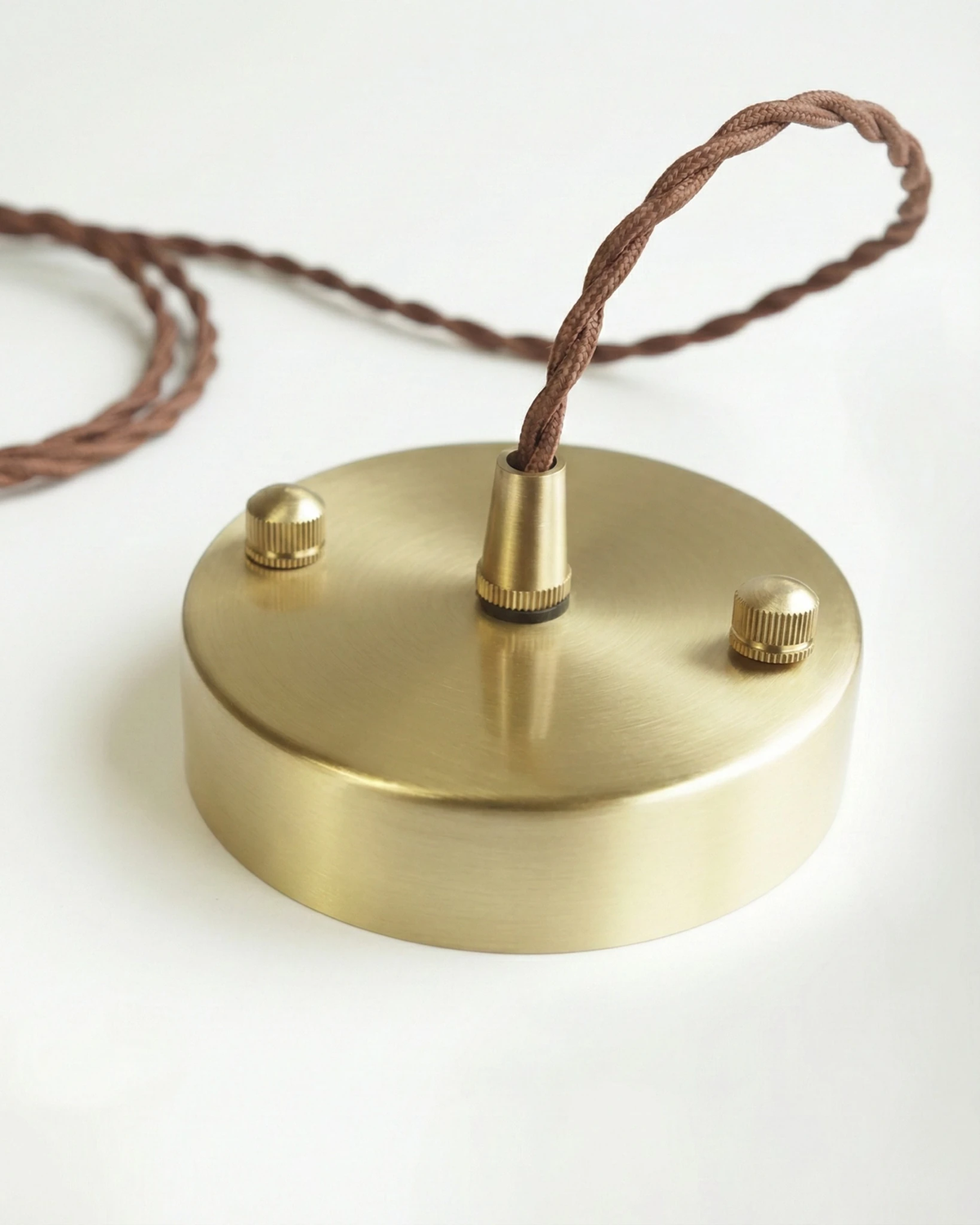 Close-up of the round copper ceiling canopy and twisted brown cord of the ALBA No.01 ceramic pendant light