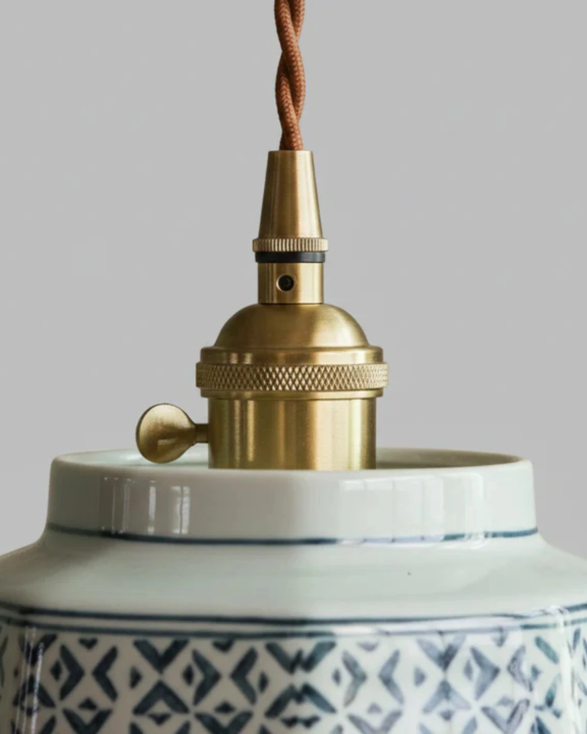 Close-up of the brass socket and white ceramic collar of the RAGUSA No.02 ceramic pendant light with painted rim
