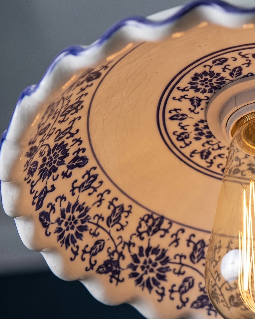 Close-up of the underside of the ceramic pendant light MELI No.01 showing the hand-painted blue floral pattern