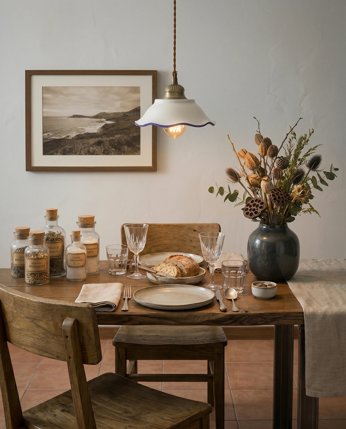 Ceramic pendant light MELI No.01 with a blue trimmed white shade, lit over a wooden dining table set with flowers