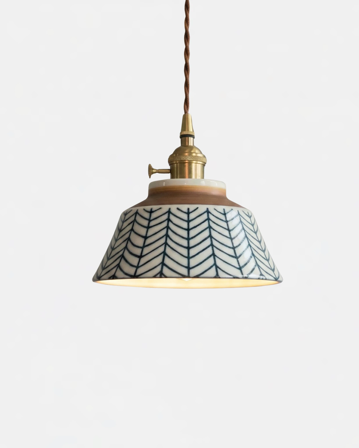 Ceramic pendant light MELI No.05 in Indigo Canvas, blue herringbone pattern on the bell shade with brass cap, lit