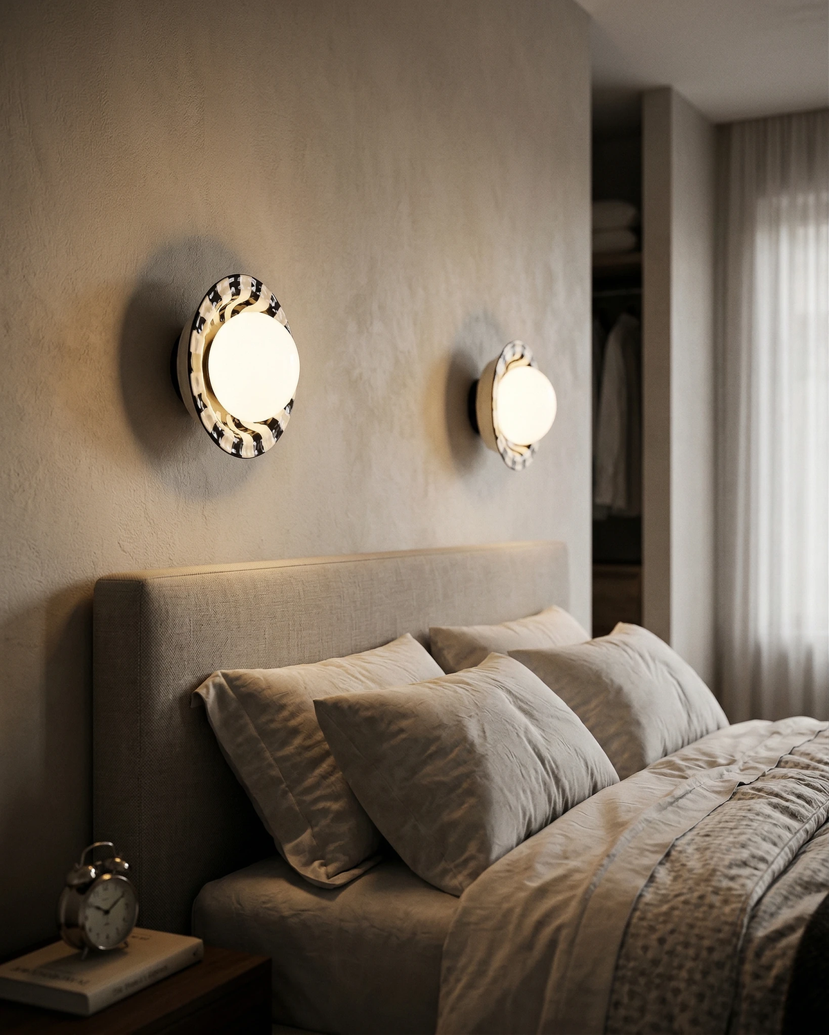 Two ceramic wall sconces OLEA No.01 with striped corolla rims and lit opal globes flanking a beige upholstered bed