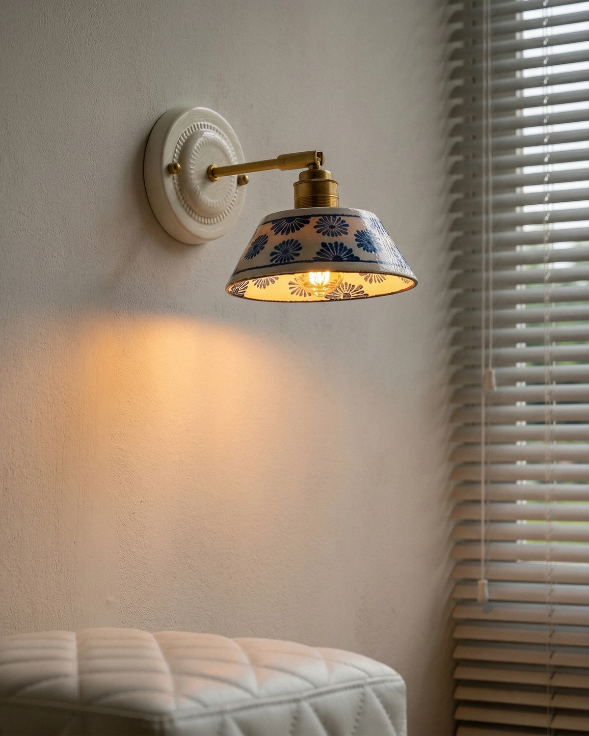 Ceramic wall sconce FIORA No.01 above a bed beside a window with blinds