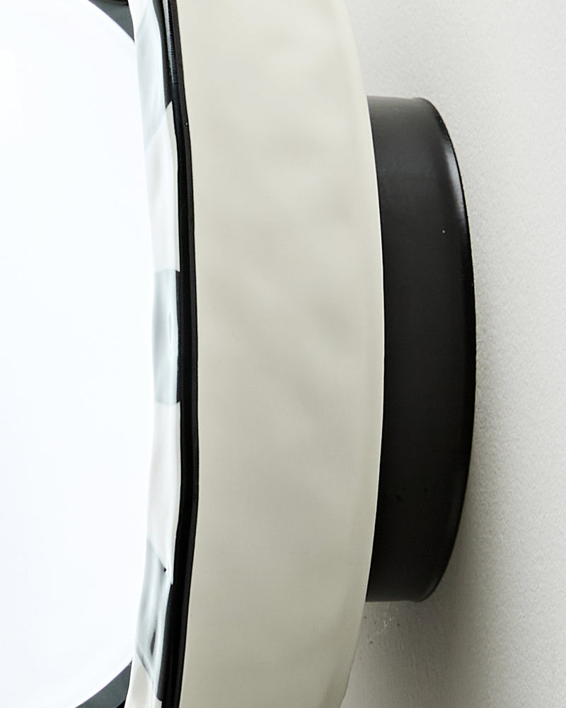 Close-up of the side of the ceramic wall sconce OLEA No.01, white ceramic corolla edge and black wall mount