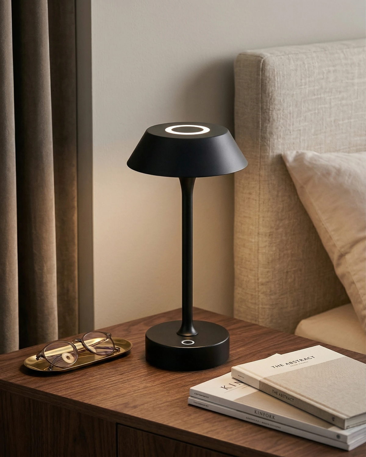 Cordless mushroom lamp CIMA No.01 in black lit on a wooden nightstand beside a bed with an upholstered headboard