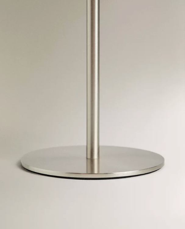 Close-up of the slim brushed silver stem and round base of the cordless mushroom lamp LUMA No.02 in Mirror Argent