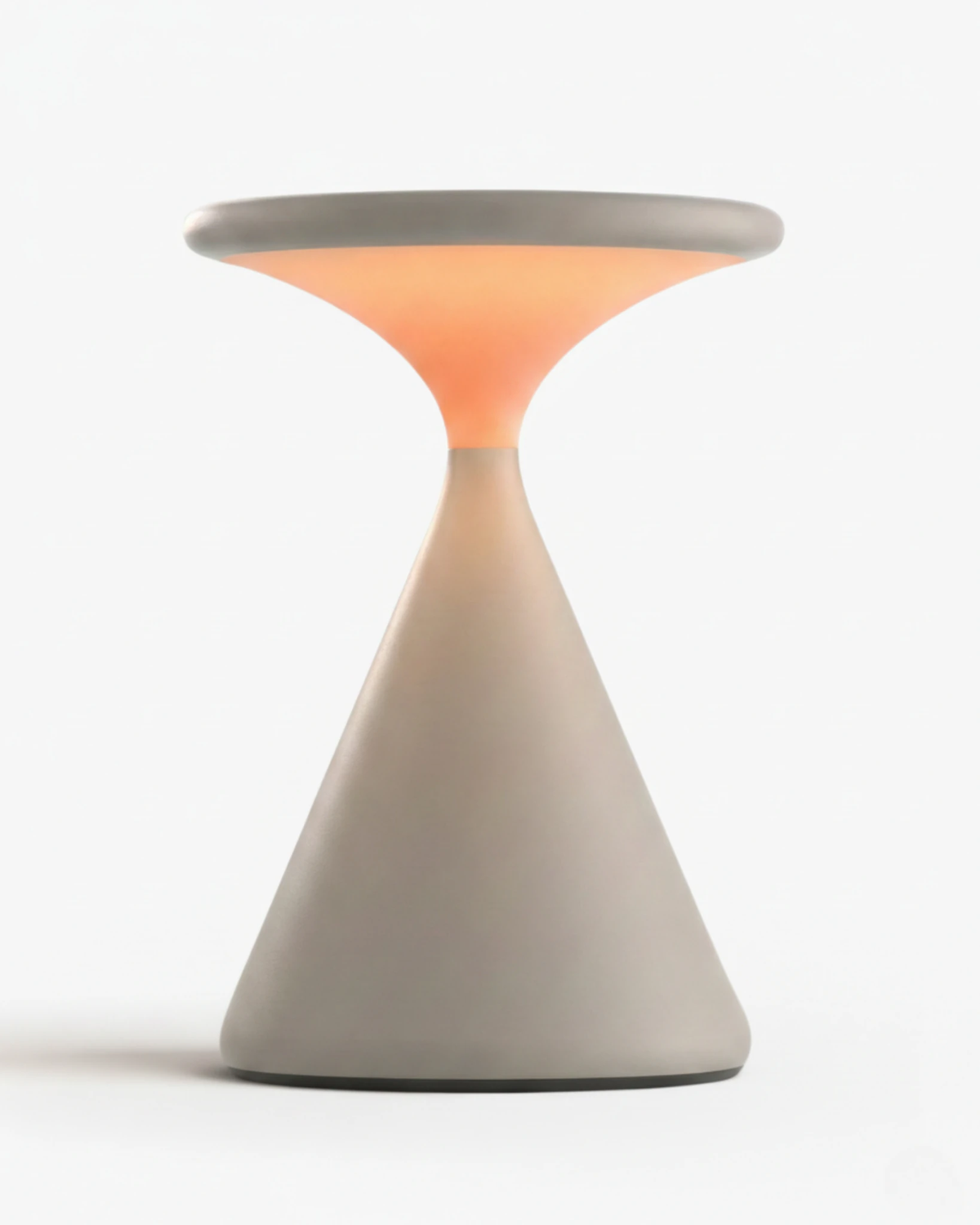 Cordless table lamp KONI No.01 in Cream, hourglass body with a warm orange glow at the waist, lit
