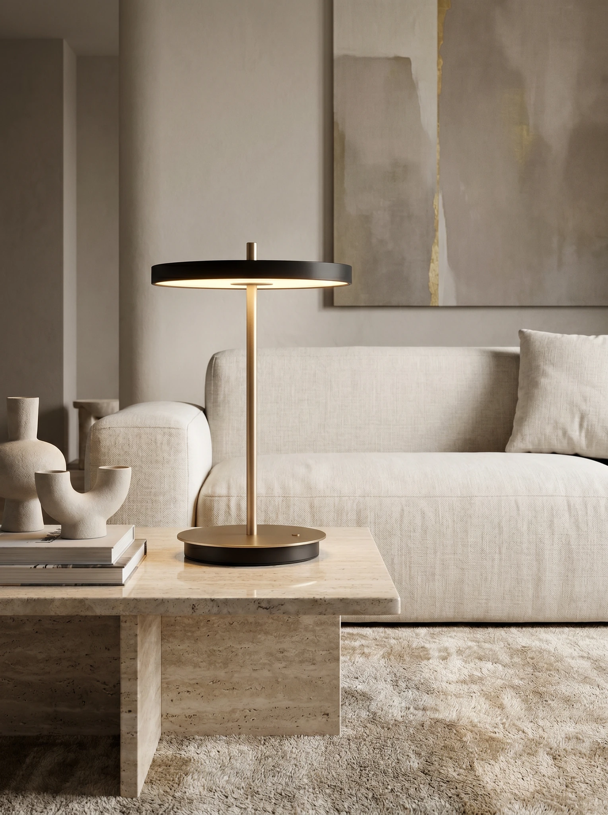 Cordless table lamp SALA No.01 in matte black, lit on a travertine coffee table in front of a boucle sofa