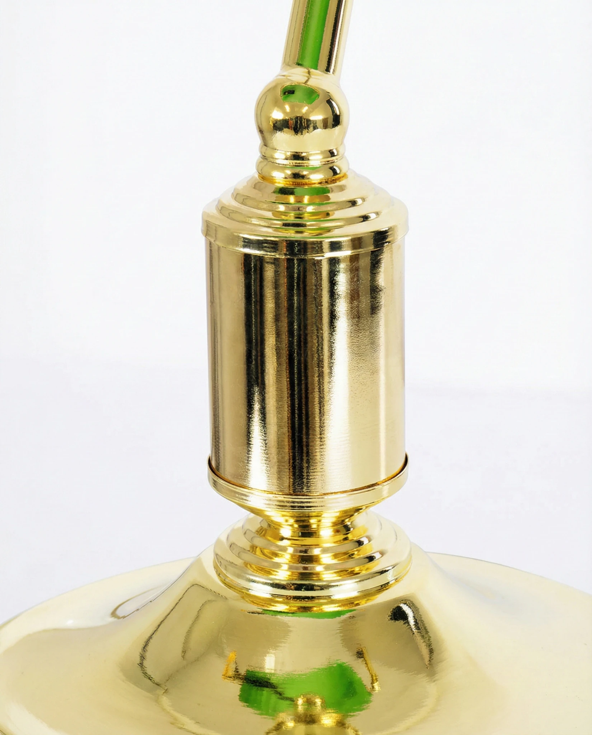 Close-up of the polished brass column and base of the BANCO No.01 glass desk lamp under the green shade