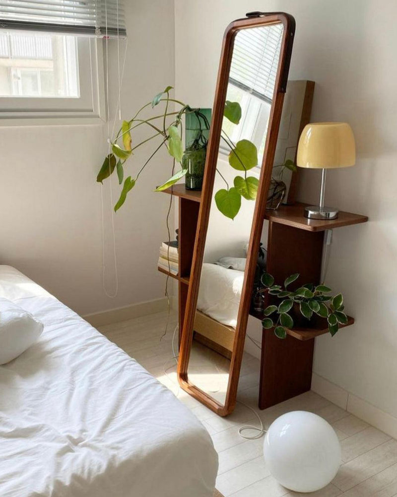 Glass table lamp VENEZIA No.01 with cream shade on a shelf beside a tall floor mirror and plants in a bedroom