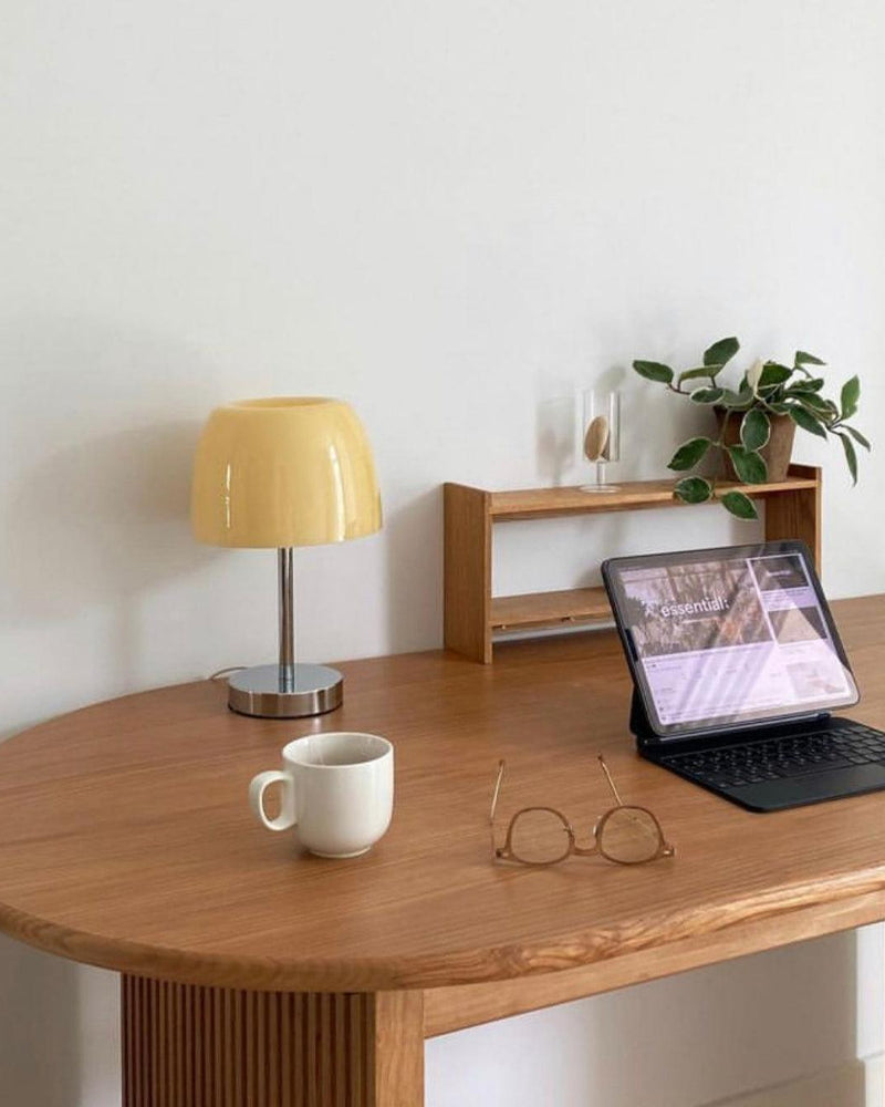 Glass table lamp VENEZIA No.01 with cream shade, unlit, on a wooden desk with a tablet, mug and reading glasses
