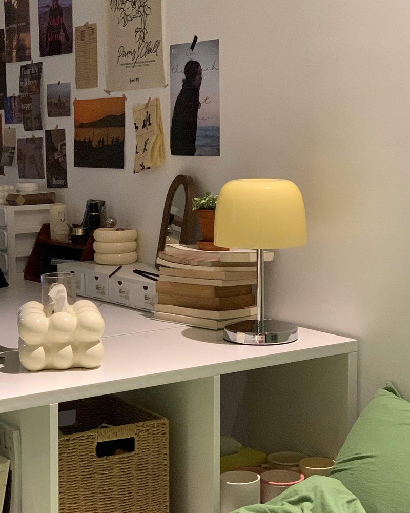 Glass table lamp VENEZIA No.01 with cream shade on a white desk with candles, a basket and pinned photos