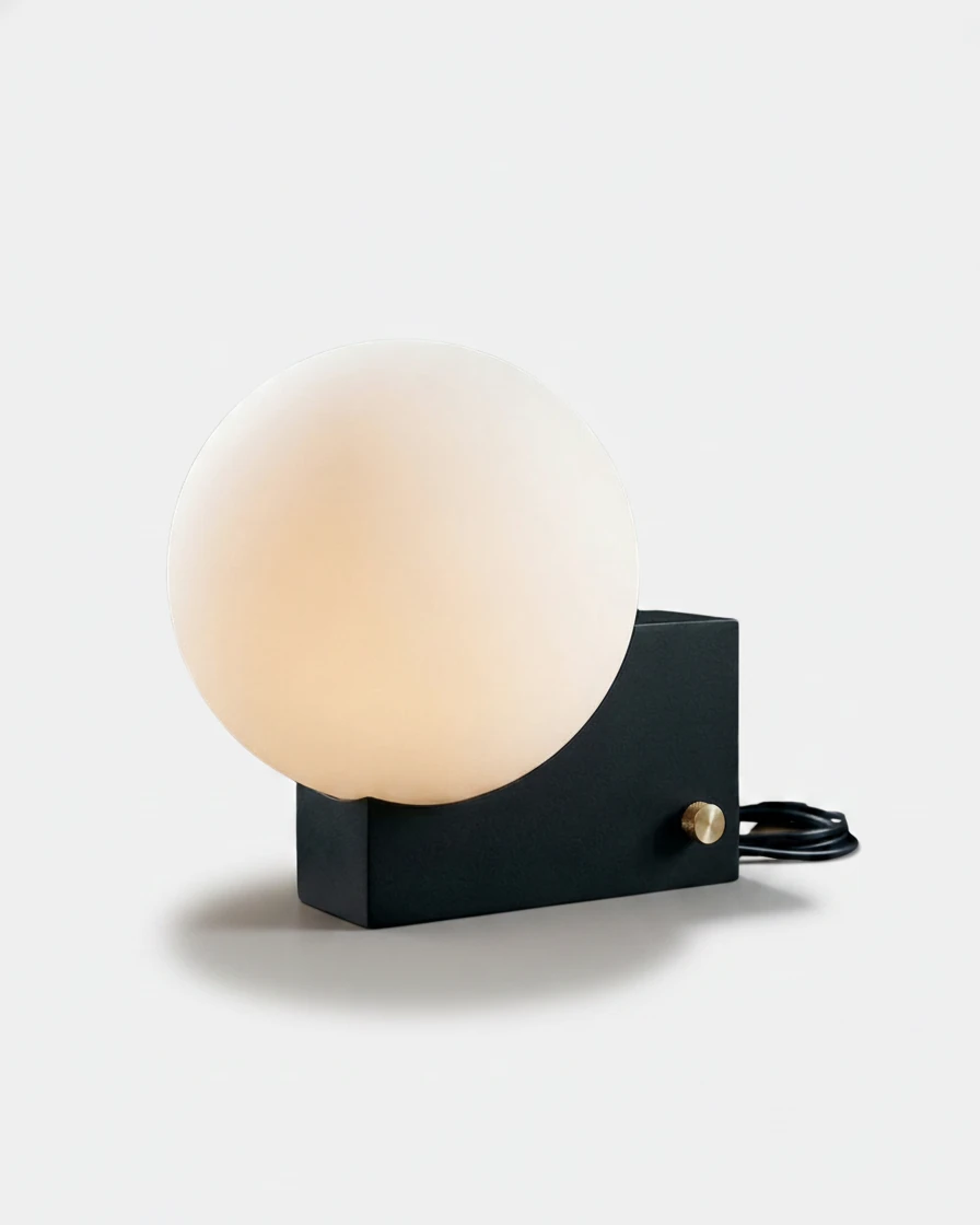 Globe desk lamp NOVA No.01 in Matte Black, opal globe on a black block base with a brass switch, softly lit
