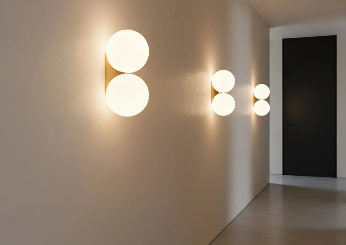 Three globe wall sconces AURA No.03 double lit in a row along a long corridor wall