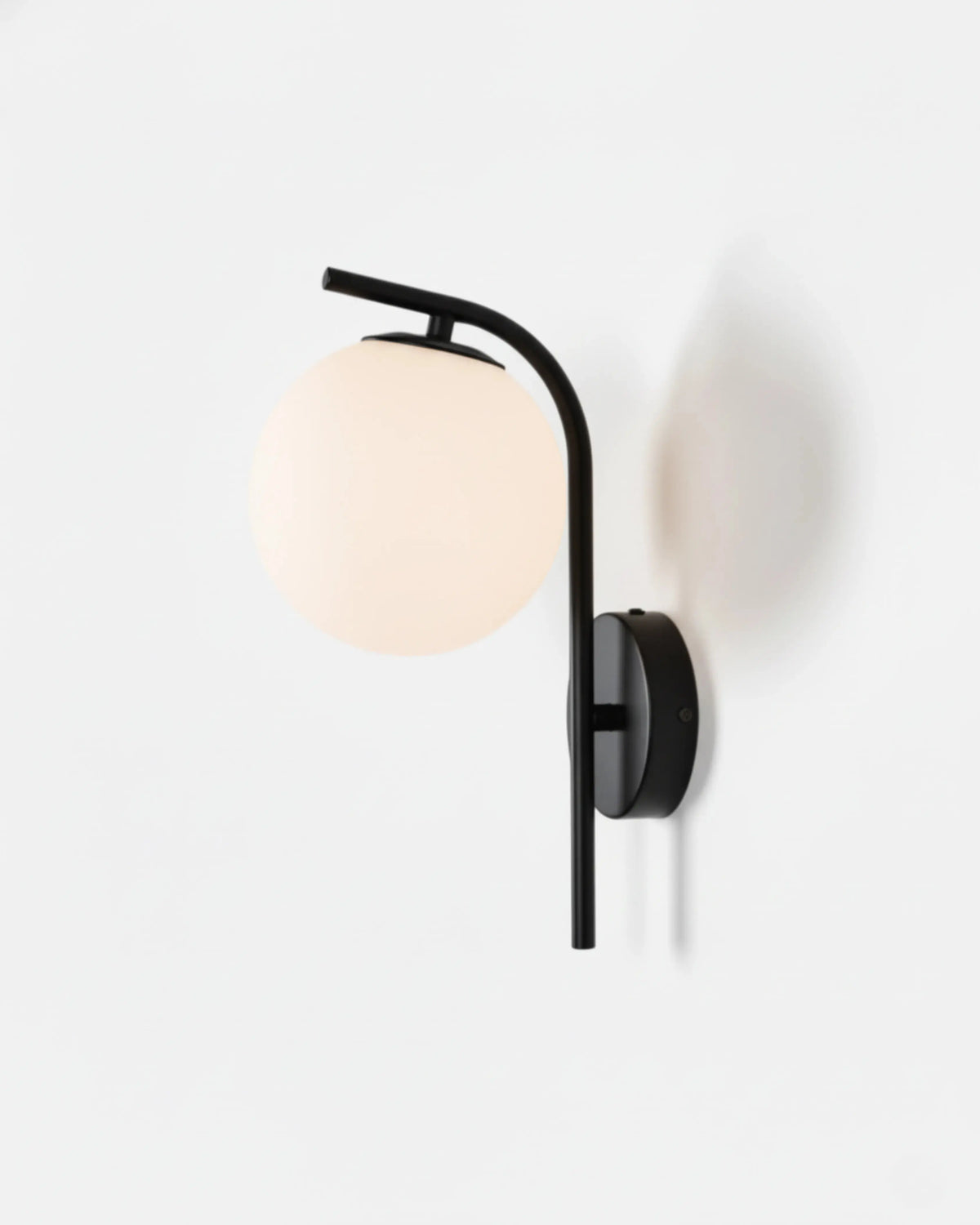 Globe wall sconce MIRA No.01 in Matte Black, white opal globe on a curved black arm and round backplate