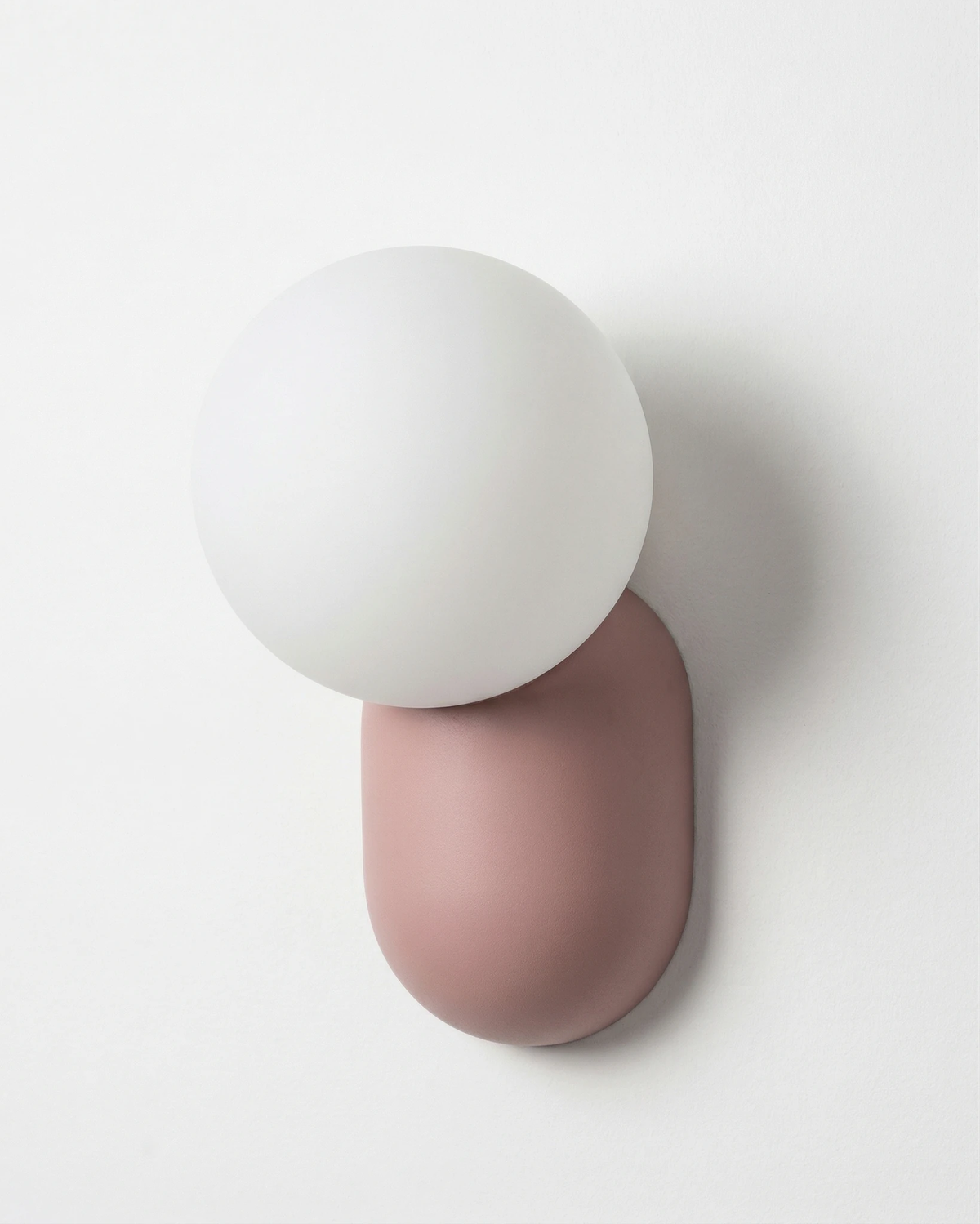 Globe wall sconce AURA No.04 in Powder Pink, white opal globe on a pink capsule, unlit