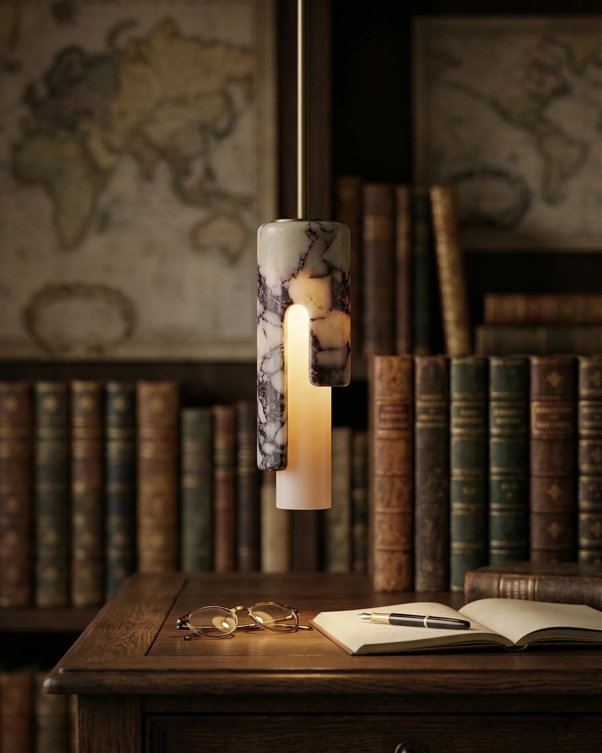 Marble pendant light PALERMO No.01 lit above an antique wood desk with an open notebook, old books and maps