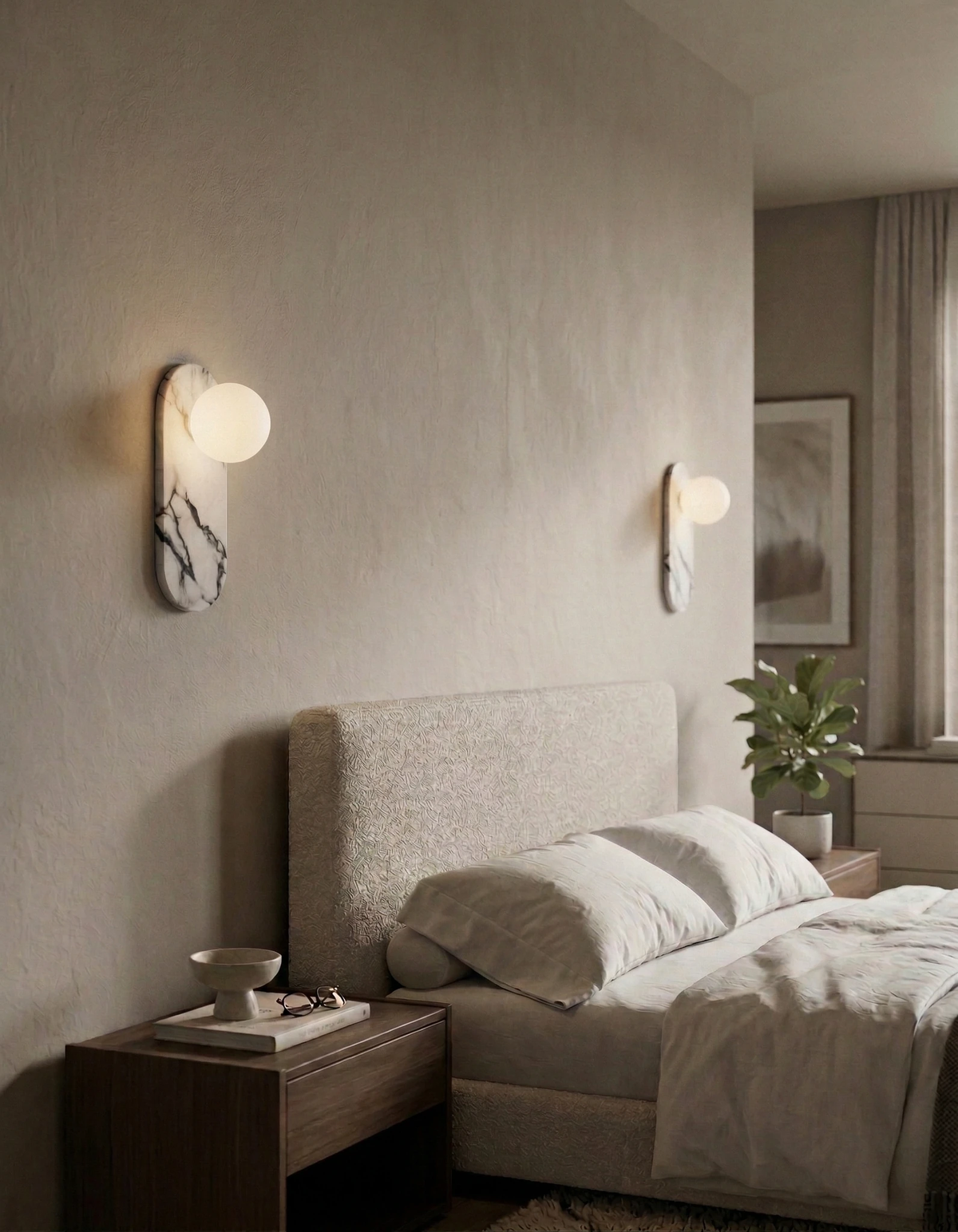 Two marble wall sconces AVOLA No.01 lit on either side of a bed with a boucle headboard