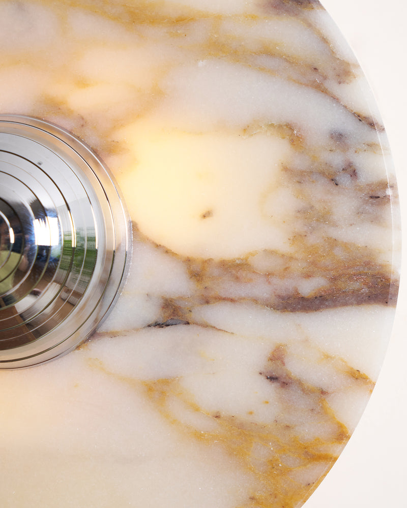 Close-up of the ribbed chrome center on the gold-veined marble disc of the LATTE No.01 marble wall sconce