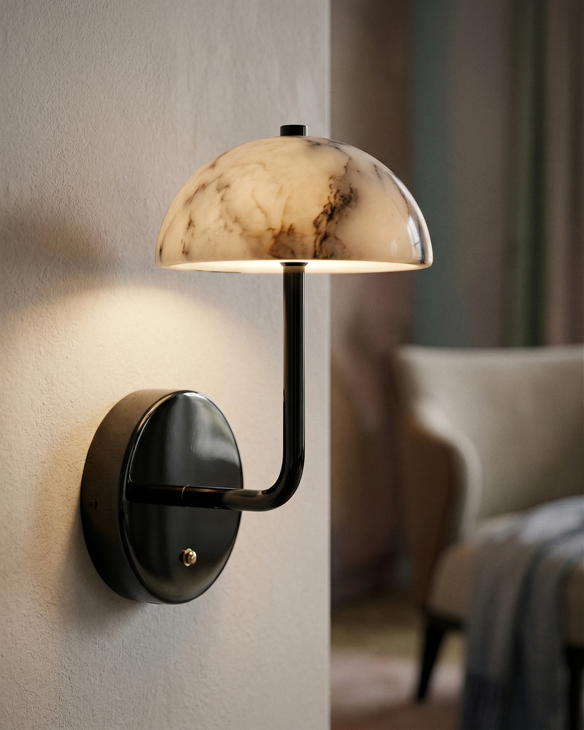 Marble wall sconce NUVOLA No.01 switched on against a white wall with a cream armchair in the background