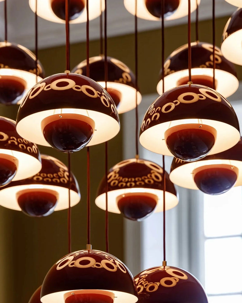 Close-up of the lit deep red petal globes of the modern chandelier FLORA No.01 showing the ring cut-outs in each shade