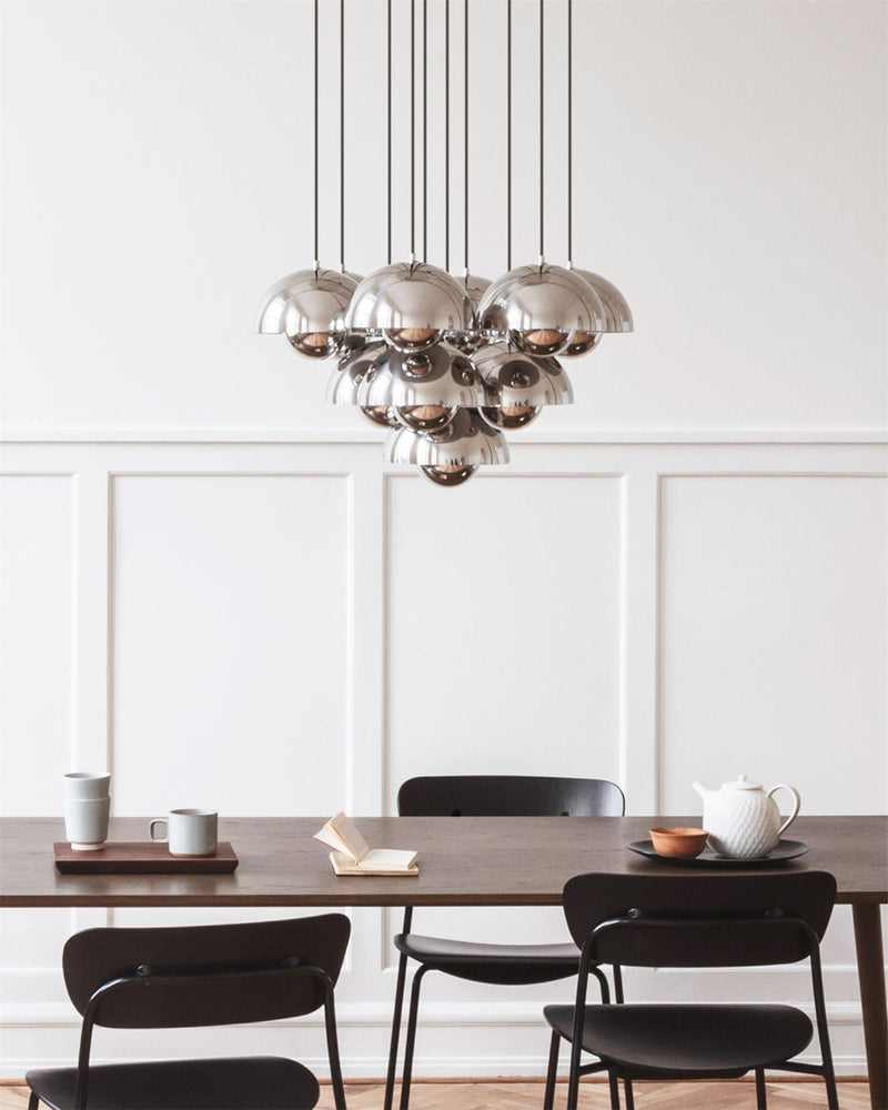 Modern chandelier FLORA No.01 in chrome mirror finish over a dark wood dining table with black chairs
