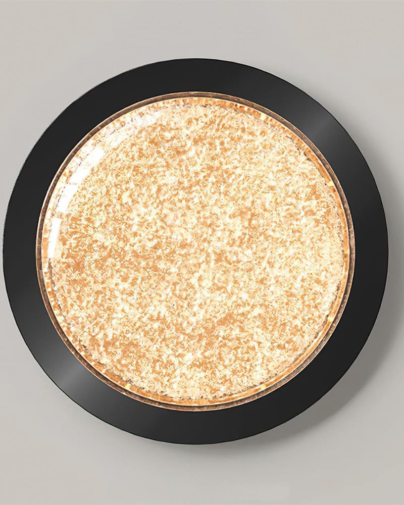 Modern flush mount ceiling light NIVE No.01 in Matte Black seen straight on, amber crystal resin disc lit in a black rim
