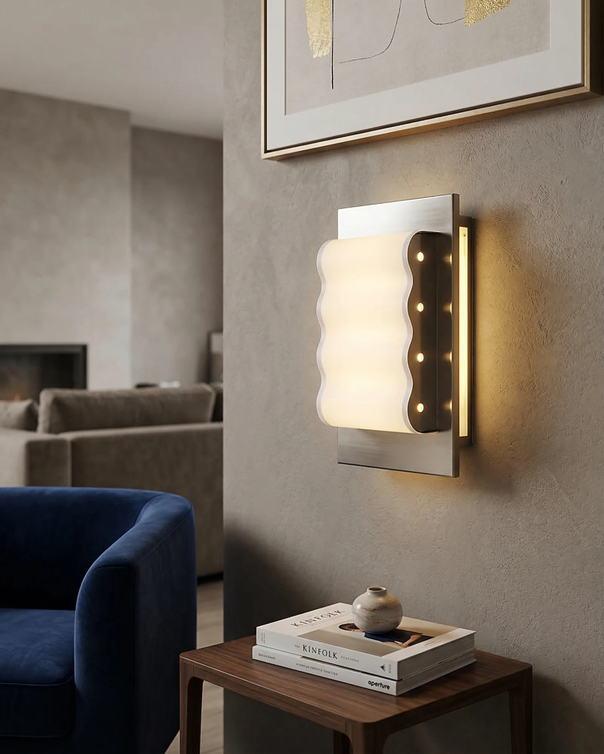 Modern wall sconce MILANO No.01 lit on a gray wall above a side table with books next to a navy armchair