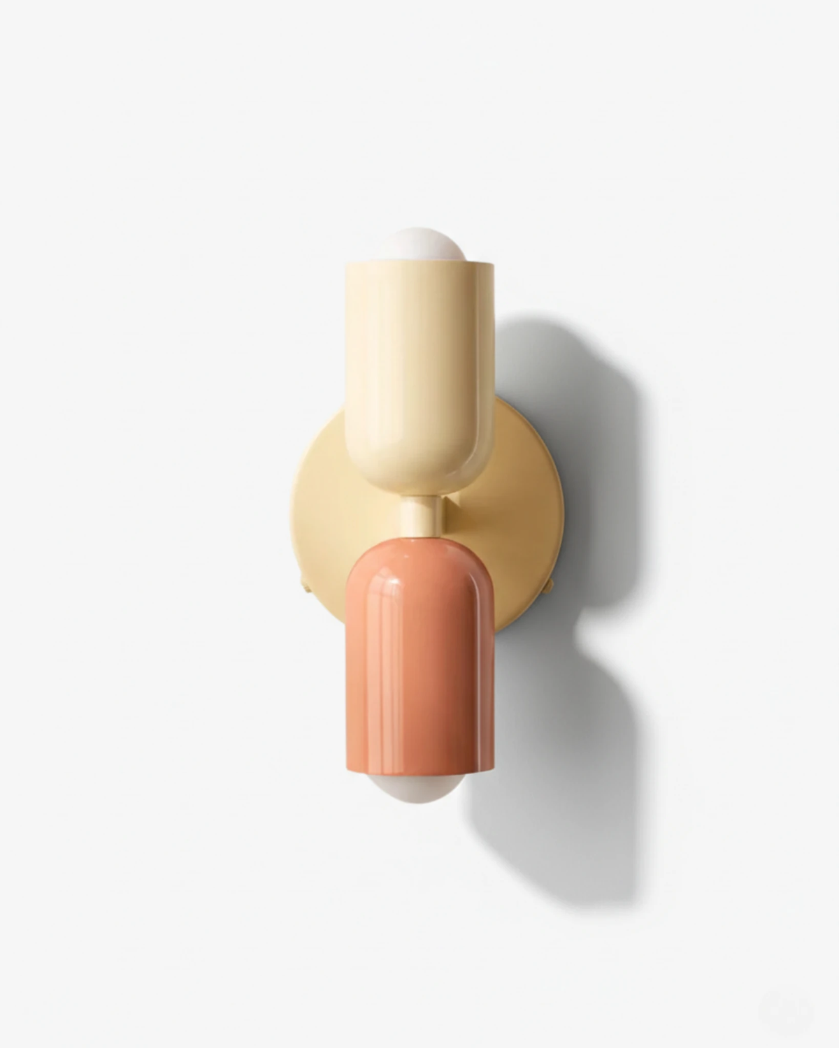 Modern wall sconce MURO No.02 in Sand & Powder Pink, cream upper and pink lower capsule on a brass disc, unlit
