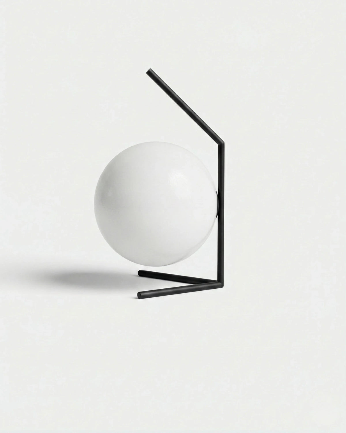 Opal globe table lamp ENNA No.01 in Matte Black, white glass globe held in an angled black rod bracket, unlit