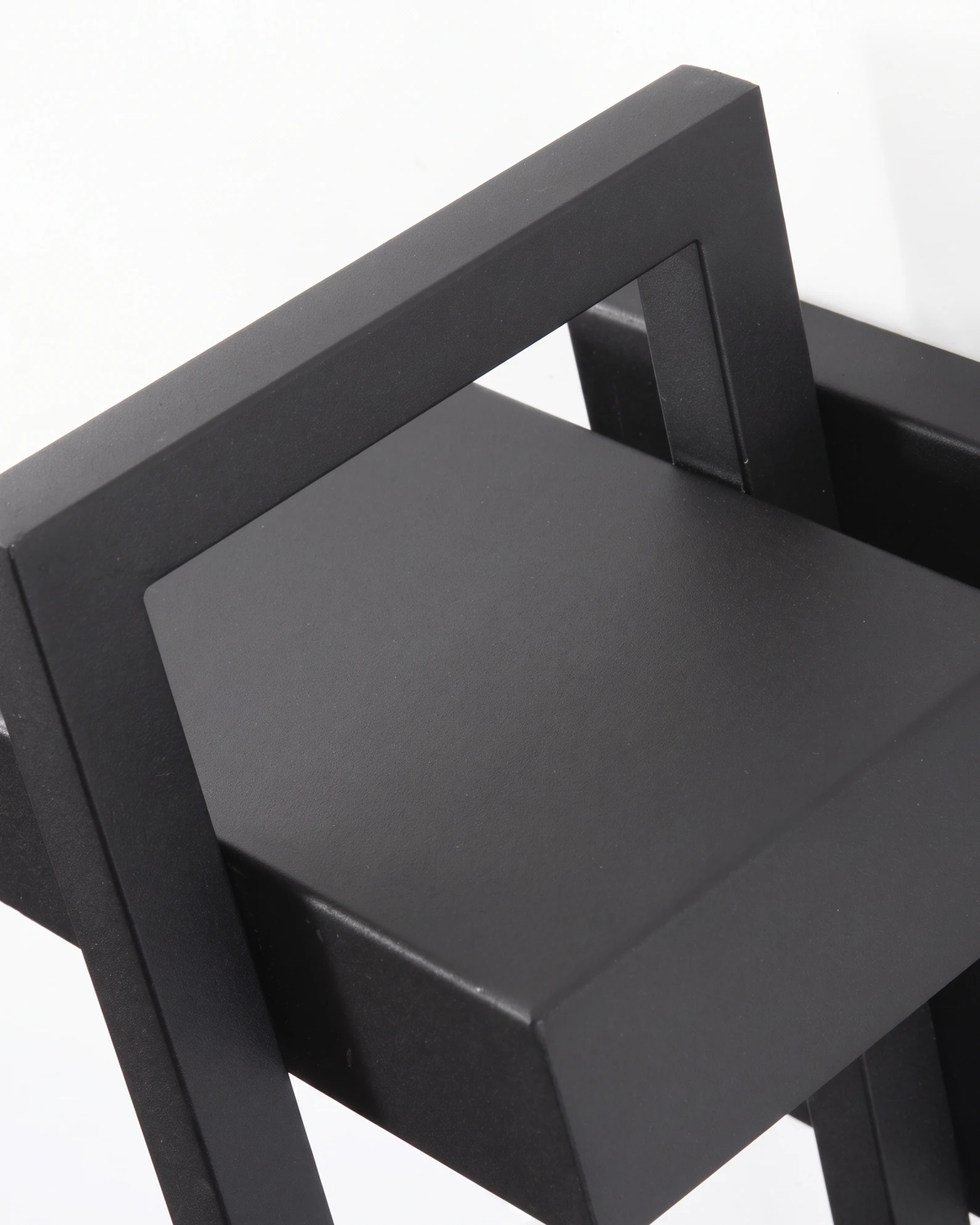Close-up of the FERRO No.01 outdoor wall sconce, top of the black steel open frame seen from an angle