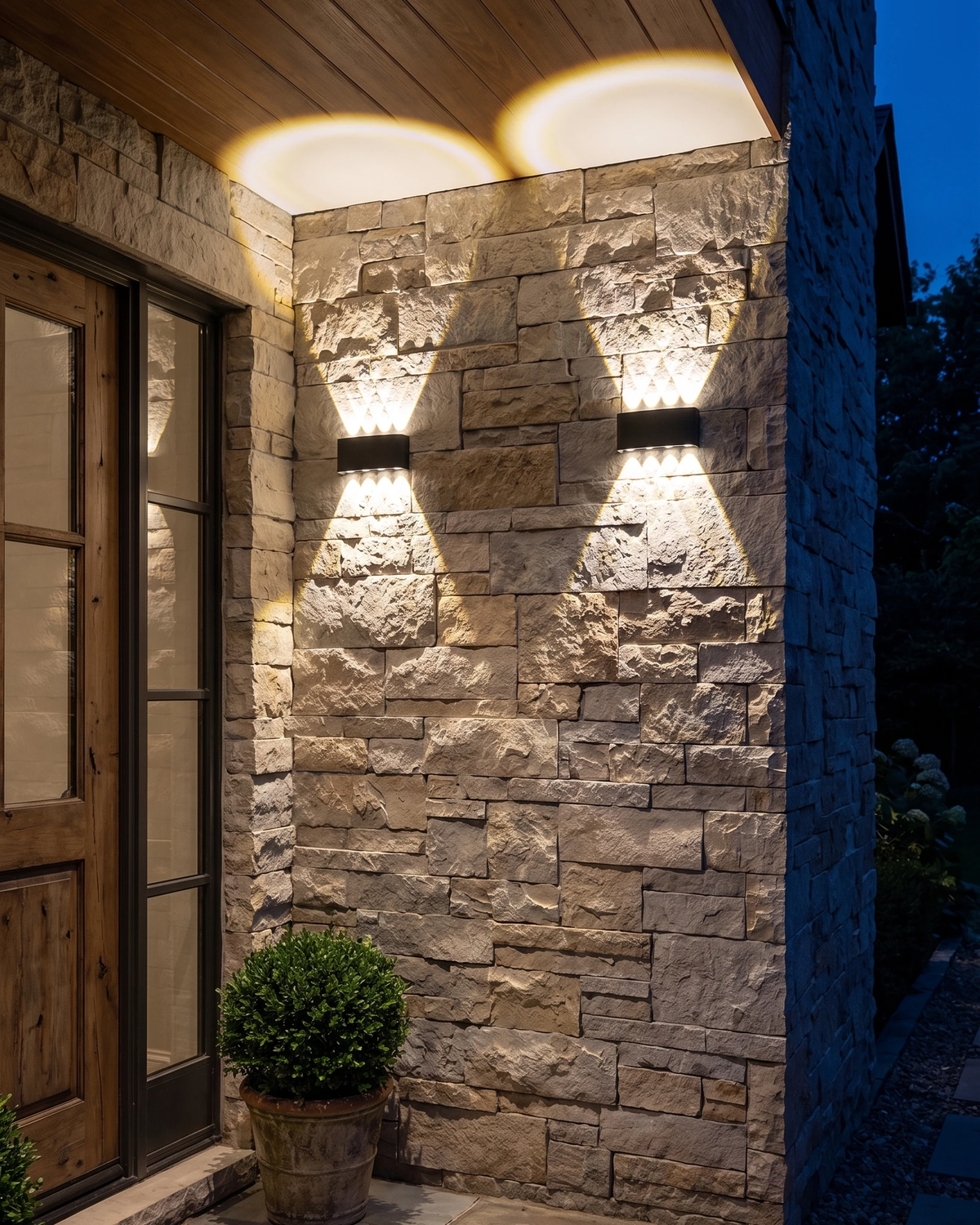 Outdoor wall sconce PALAZZO No.01 in matte black, two units lit on a stone wall beside a front door at night