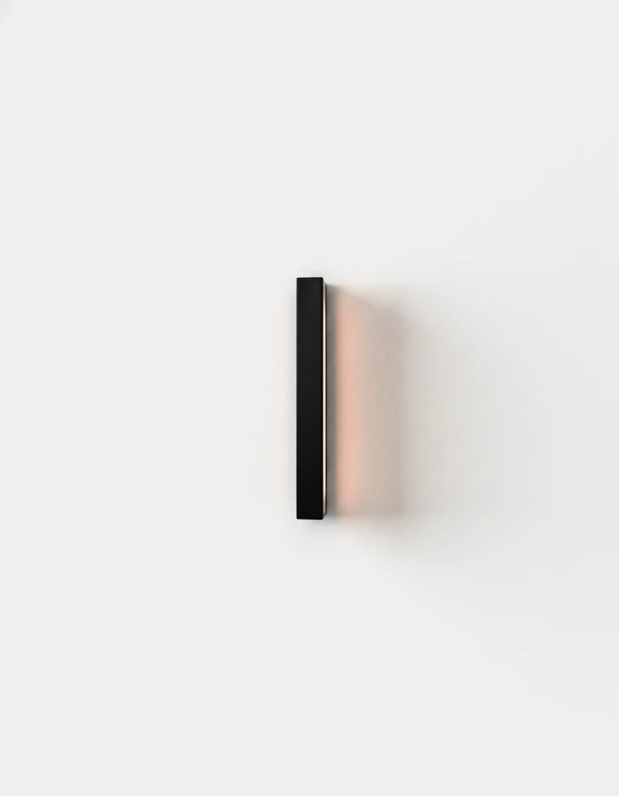 Outdoor wall sconce FRECCIA No.01, 40 cm (15.7 in) black linear bar mounted vertically and lit against a white wall