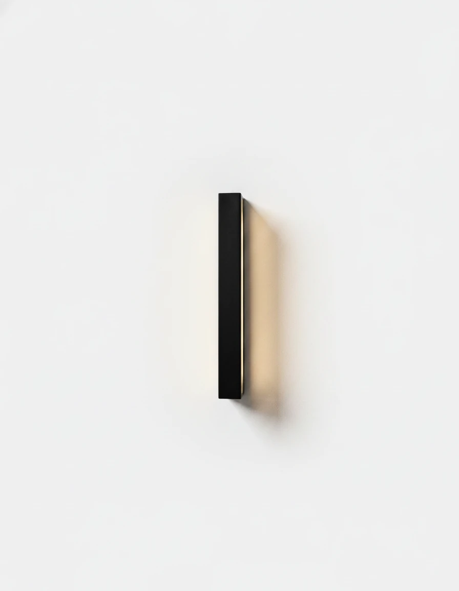 Outdoor wall sconce FRECCIA No.01, 60 cm (23.6 in) matte black bar lit, casting a warm halo on the wall behind