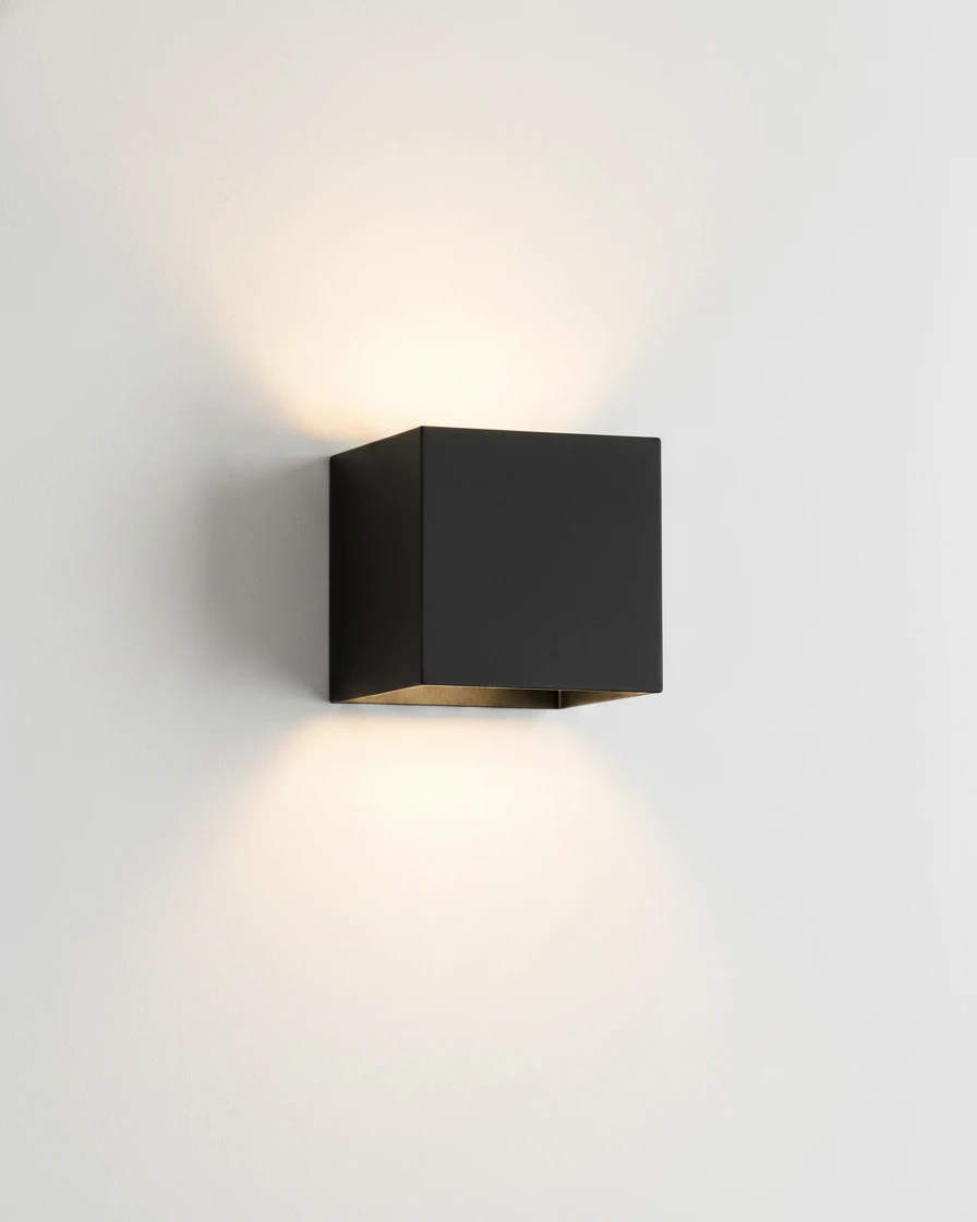 Outdoor wall sconce FARA No.01 in matte black, cube switched on casting light up and down a white wall
